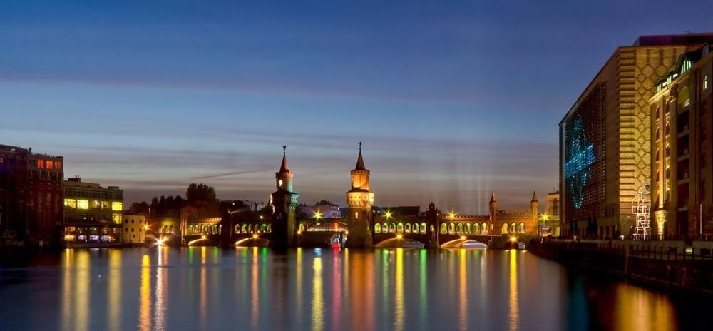 architecture, built structure, building exterior, waterfront, water, reflection, illuminated, river, city, sky, connection, bridge - man made structure, travel destinations, canal, famous place, blue, outdoors, no people, night, bridge