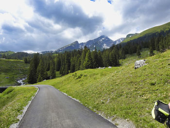 Road amidst green landscape against sky