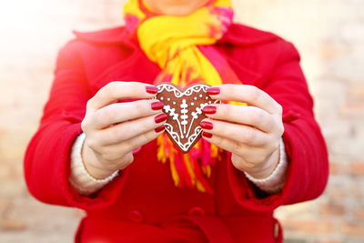 Midsection of woman holding gingerbread cookie during christmas