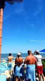 Rear view of woman sitting on beach