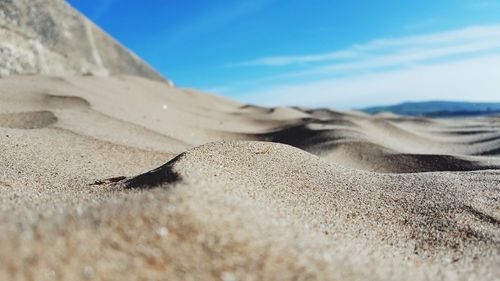 Surface level of sand against sky