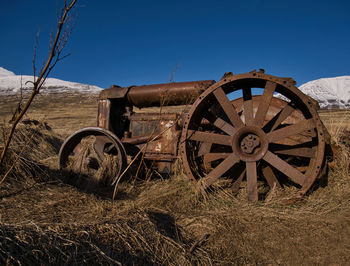 Abandoned truck on field against clear sky