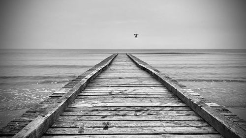 Pier over sea against sky