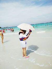 People on beach against sky