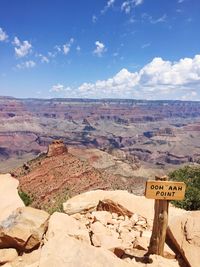 Information sign on rock against sky