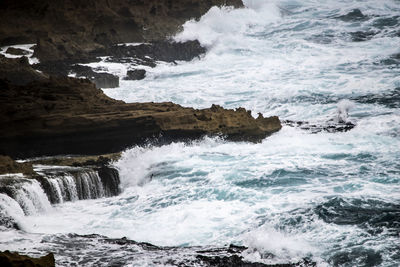 Scenic view of sea waves splashing on rocks