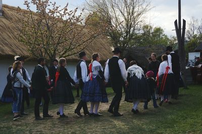 People on grassland against sky