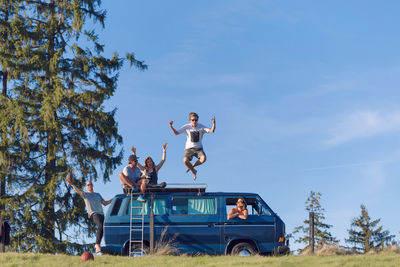 Group of friends having fun at van in the nature