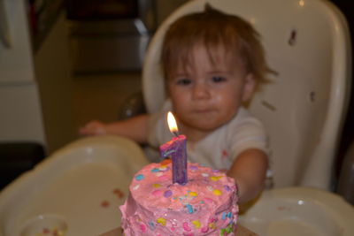 Baby girl looking at birthday cake