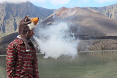Man standing in lake against mountains