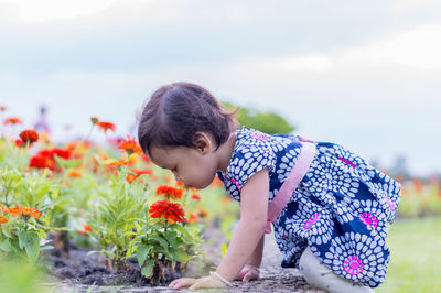 Side view of girl looking at flowering plants