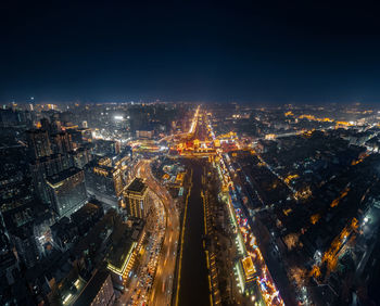 High angle view of illuminated cityscape against sky at night