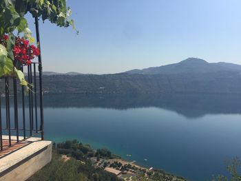 Scenic view of lake and mountains against clear blue sky