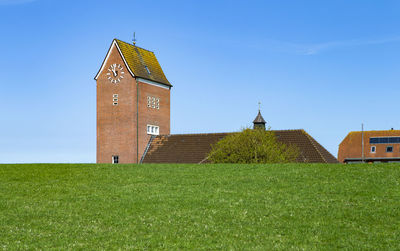The photo shows a church behind the dam on the north sea island baltrum in germany