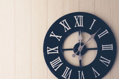 Close-up of clock on wooden wall