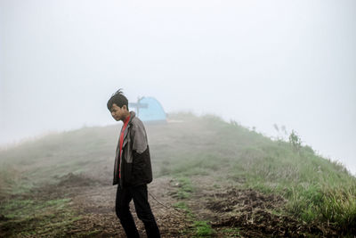 Man standing on field against sky