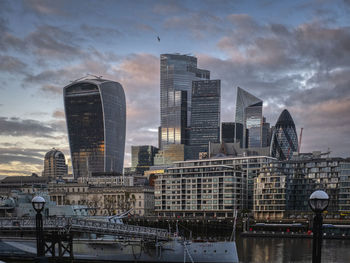 Modern buildings in city against cloudy sky