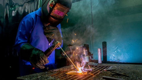 Man welding metal at workshop