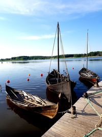 Boats moored in sea against sky