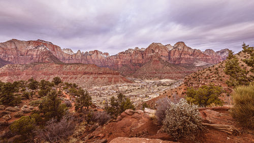 Rock formations on landscape against cloudy sky