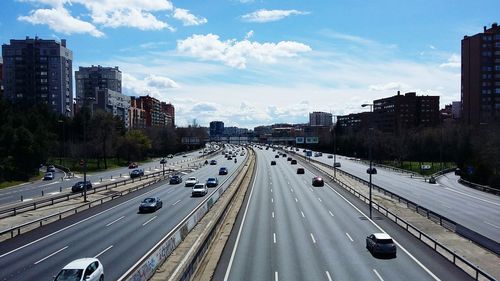 Traffic on road in city against sky