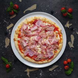 Traditional italian pizza with ham, salami, bacon and roasted pork