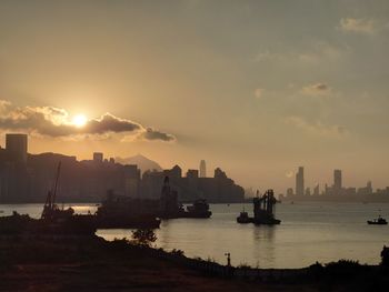 Silhouette boats in sea against sky during sunset