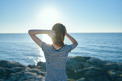 Woman looking at sea against sky