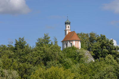 Romantic chapel on hill in bavaria against sky