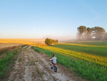 Little boy riding bike in countryside. riding person at sunset in nature. 