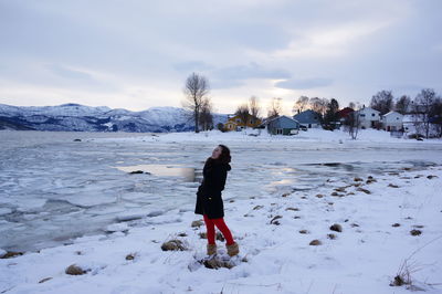 Full length of woman standing on snow covered landscape