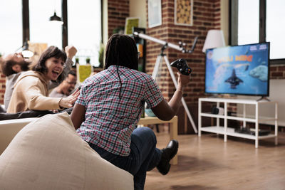 Rear view of business colleagues playing games in office