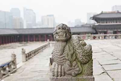 Close-up of statue against buildings in city