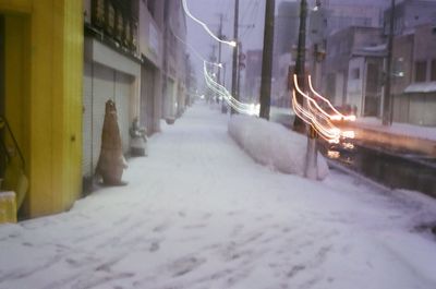 Illuminated snow covered buildings at night