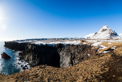 Scenic view of snowcapped mountains against clear blue sky