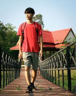 Full length of teenage girl standing on footbridge