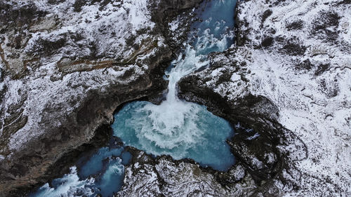 The aldeyjarfoss waterfall in northeastern iceland surrounded by beautiful rock formations.