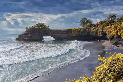 Rocks on beach against sky in tanah lot,bali