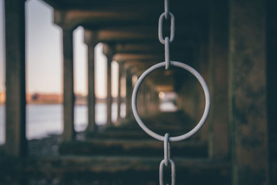 Chain hanging in bridge by river