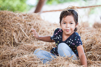 Portrait of girl playing on hay 