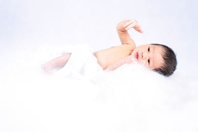 A newborn baby laying on a white bed. newborn child or adorable baby sleeping in a white bed.