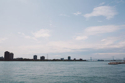 Sea by cityscape against sky