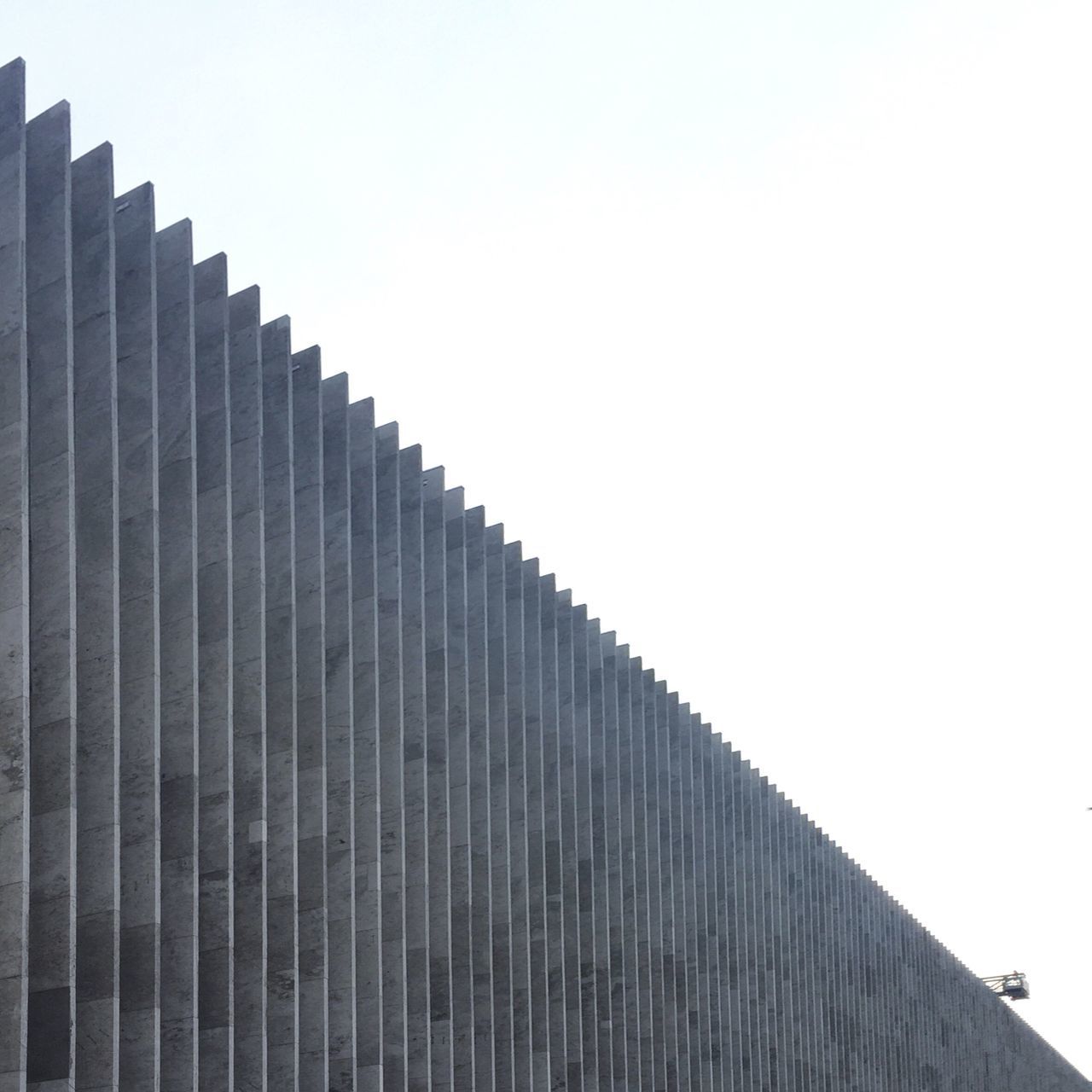 clear sky, architecture, copy space, low angle view, built structure, building exterior, building, in a row, high section, no people, outdoors, sky, tall - high, day, overcast, city, modern, repetition, wall - building feature, pattern