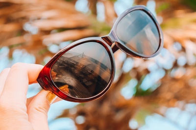 Close-up of hand holding sunglasses