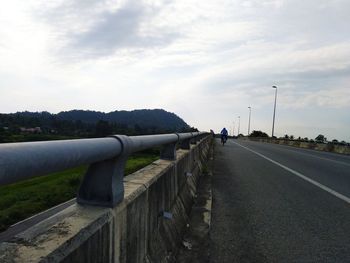 Empty road against sky in city