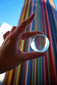 Low angle view of hand holding crystal ball