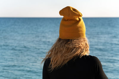 Rear view of woman looking at sea against sky