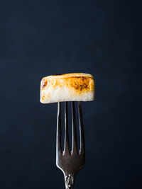 Close-up of bread in plate against black background