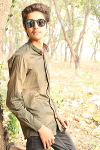 Portrait of young man wearing sunglasses standing outdoors