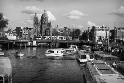 Boats on lake against buildings in city